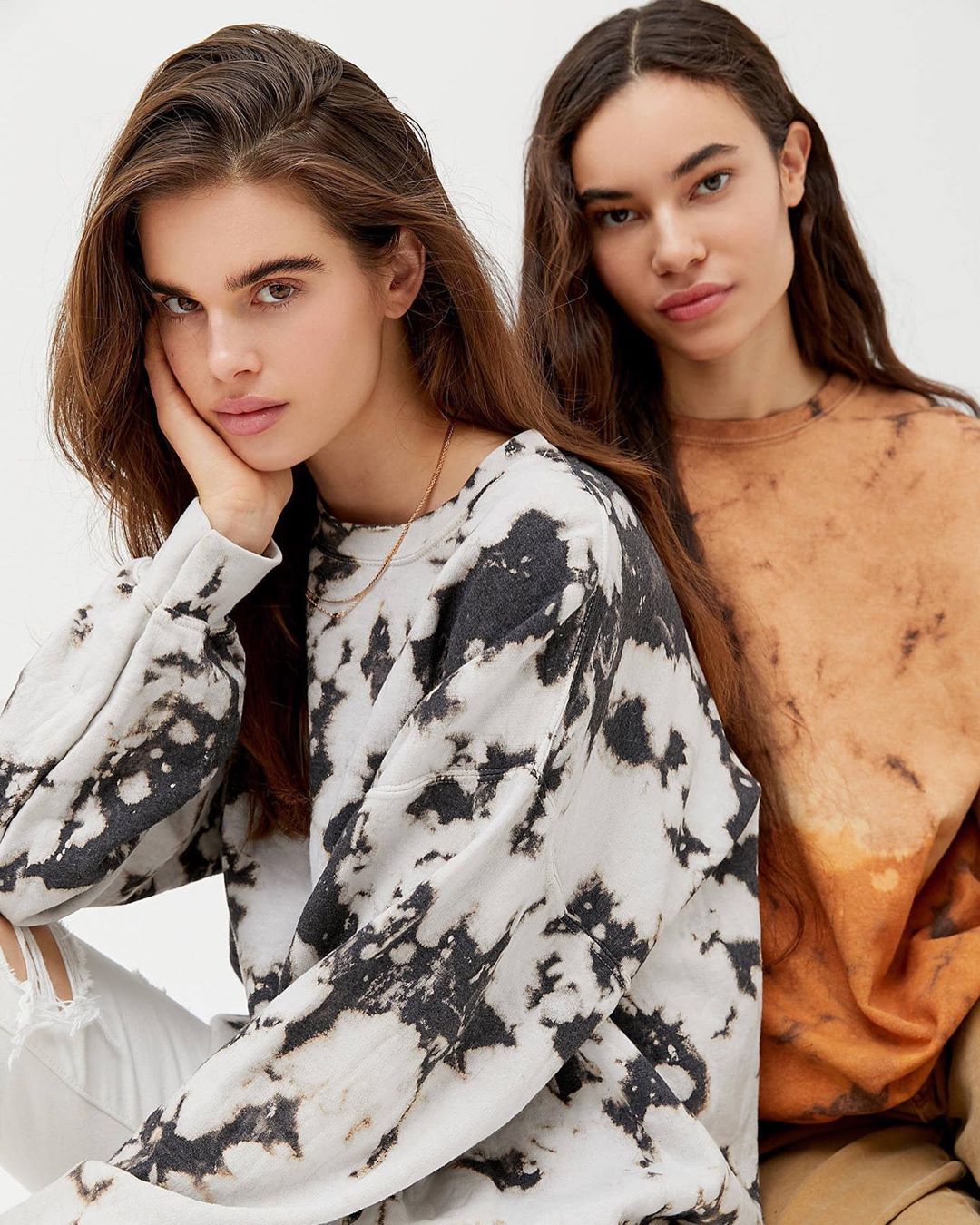 Two models posing in Urban Outfitters sweatshirts 