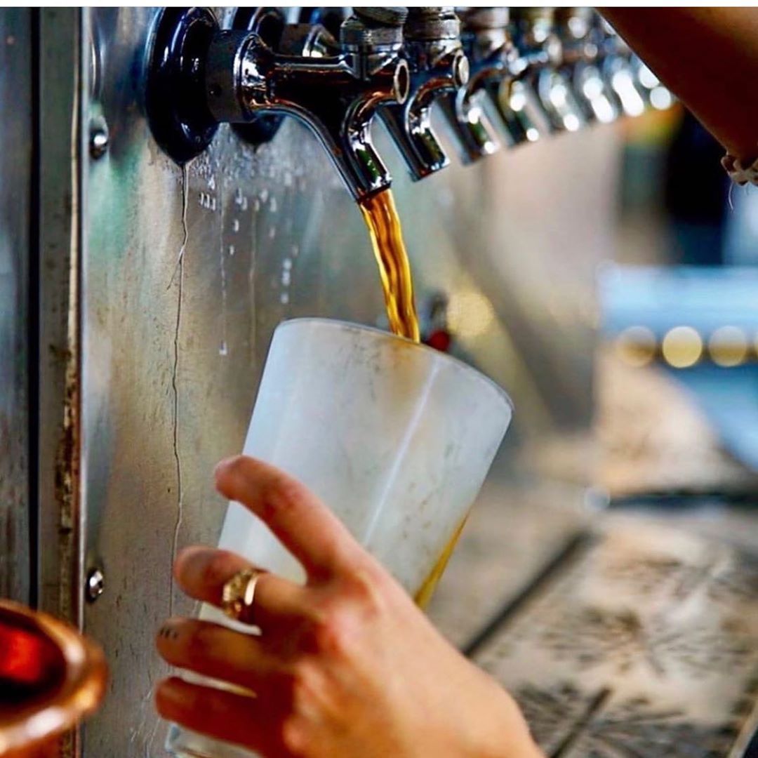 woman pouring beer from a tap