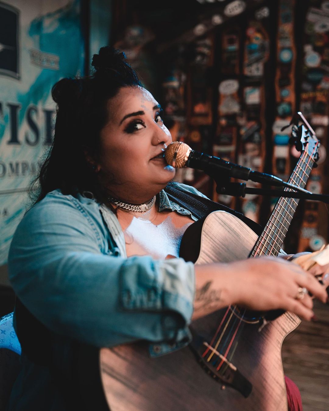 Woman sitting playing guitar and singing 