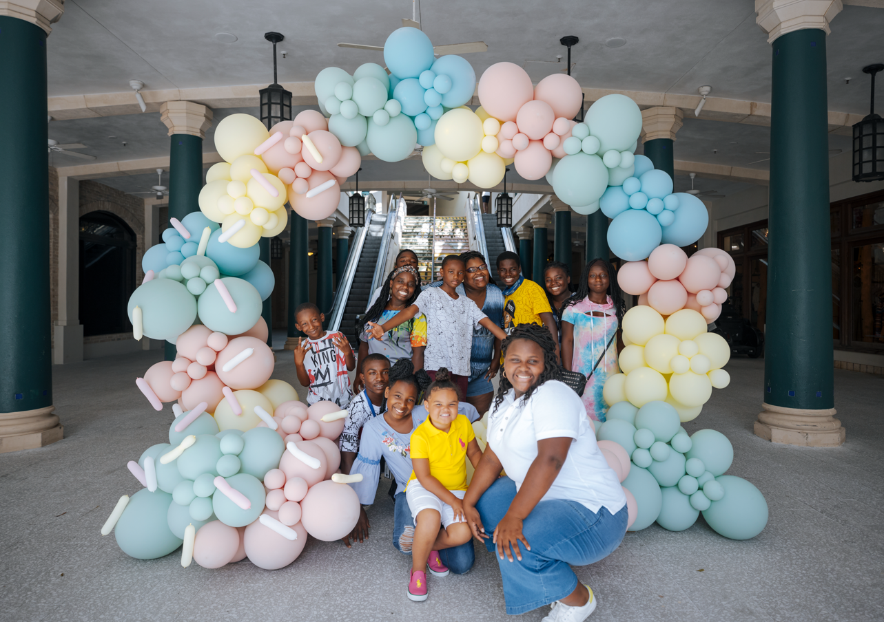 Family posing in front of balloon arch