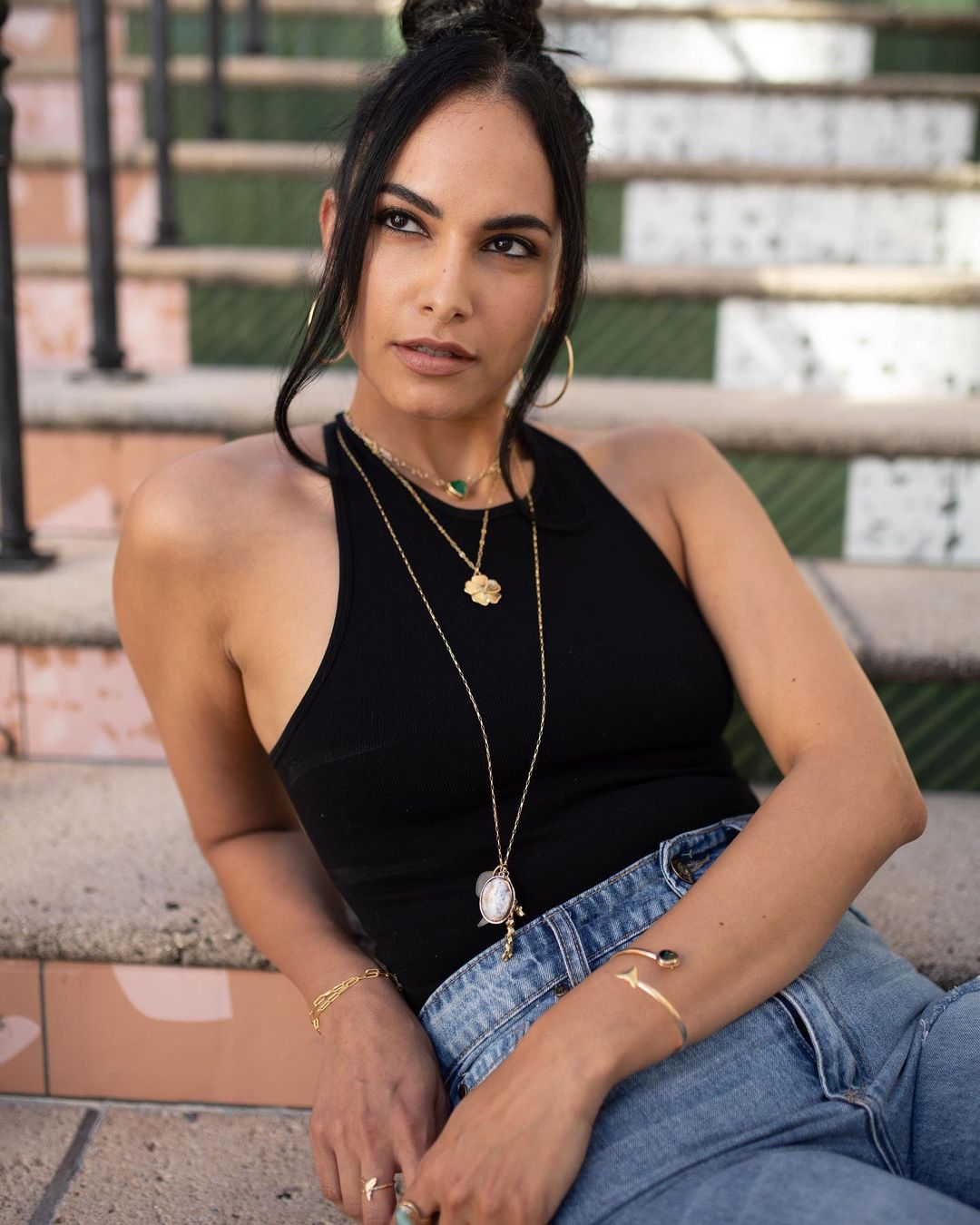 woman posing on stairs with necklaces 