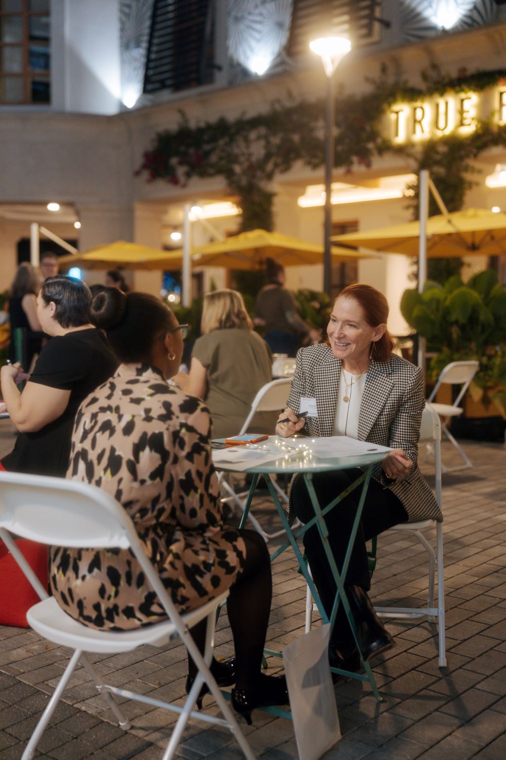 Woman sitting  at a table interviewing another person on the other side of the table