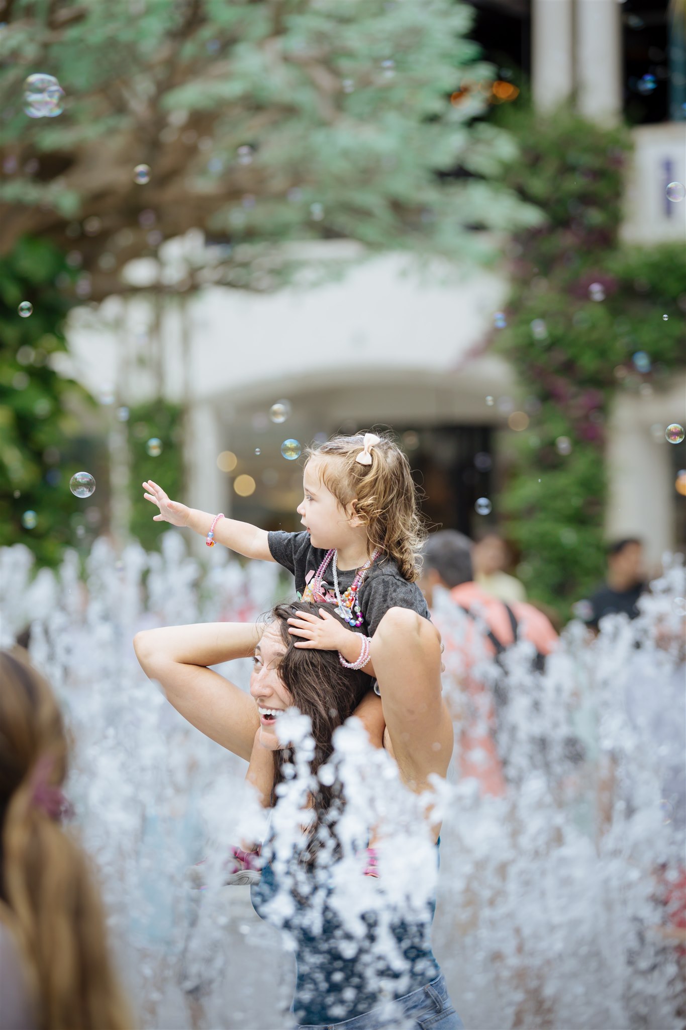 Mom and child in water fountain 