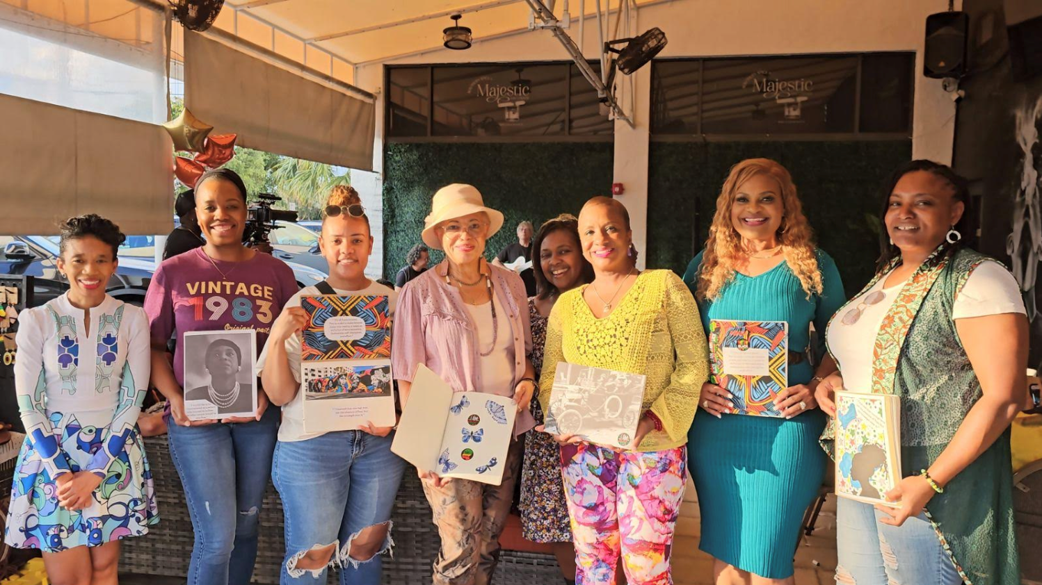 seven women standing together and holding their projects 