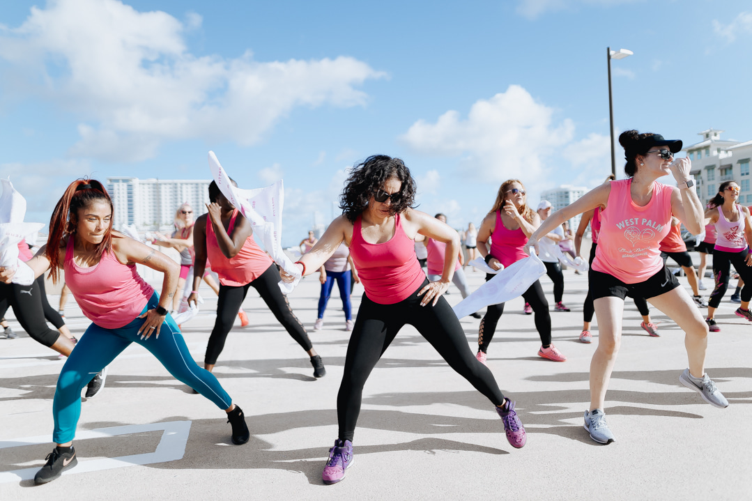 women in pink shirts exercise outdoors