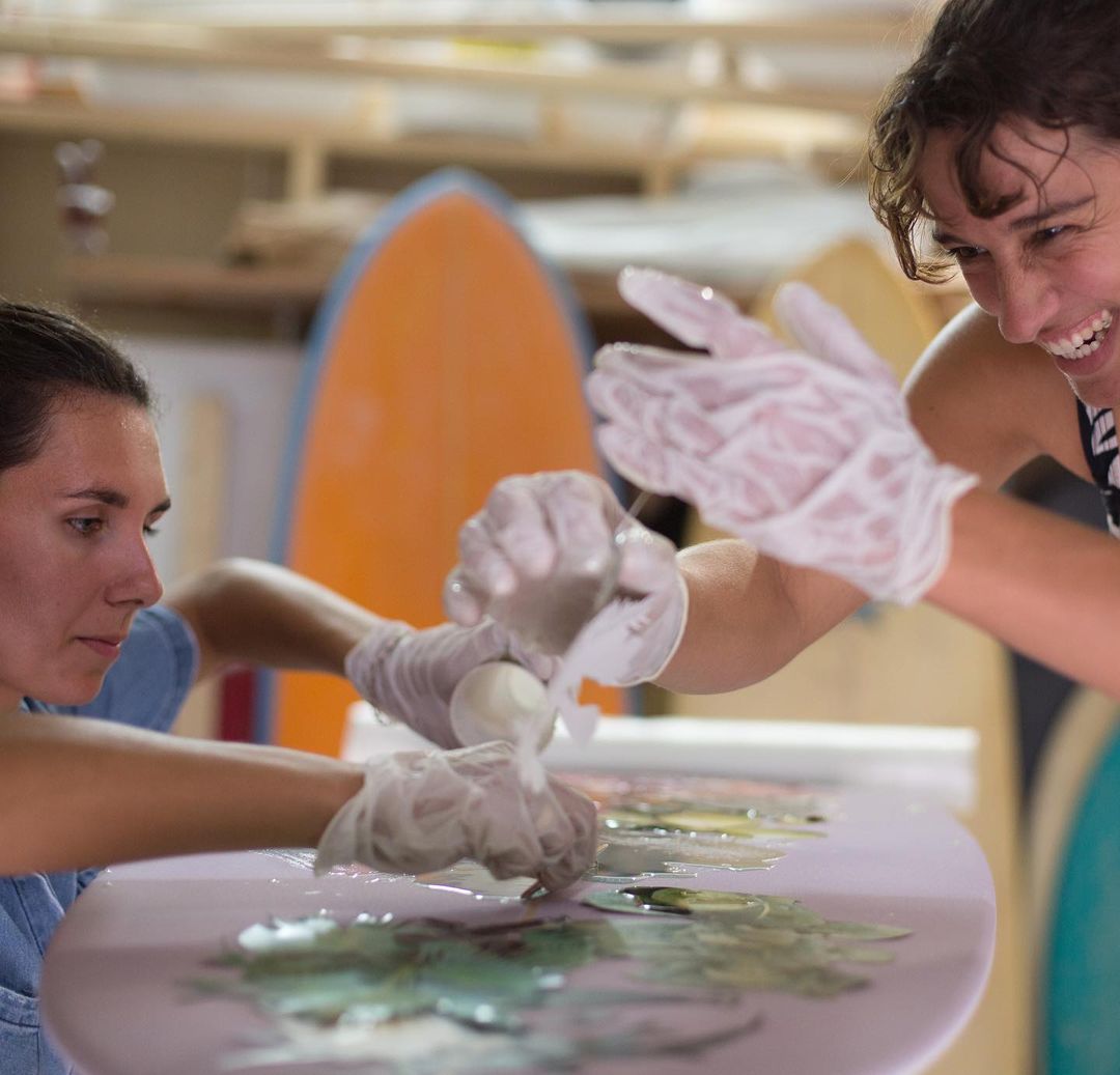 Two woman designing a surfboard