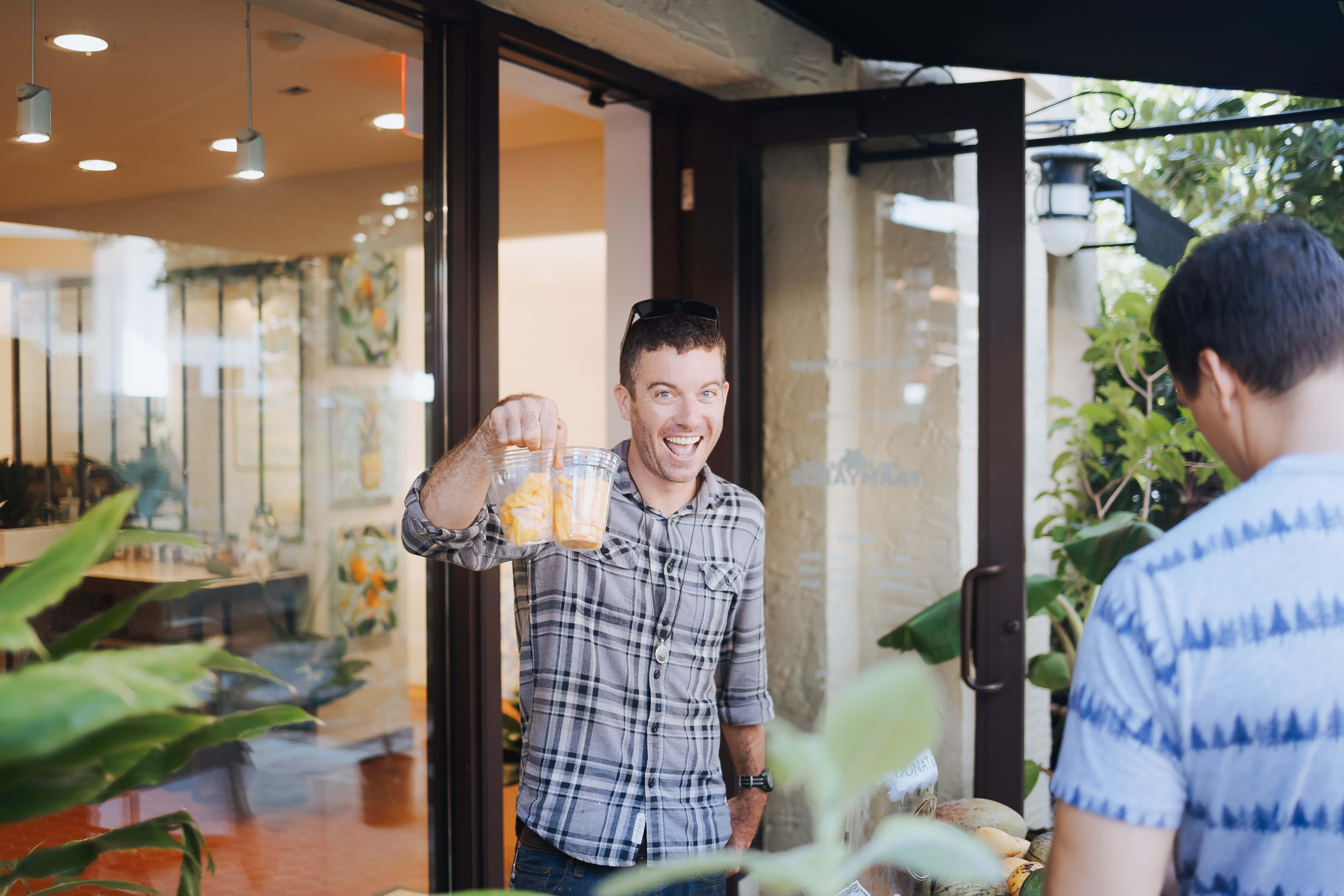 man holds up drinks in one hand