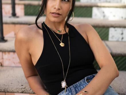 woman posing on stairs with necklaces 