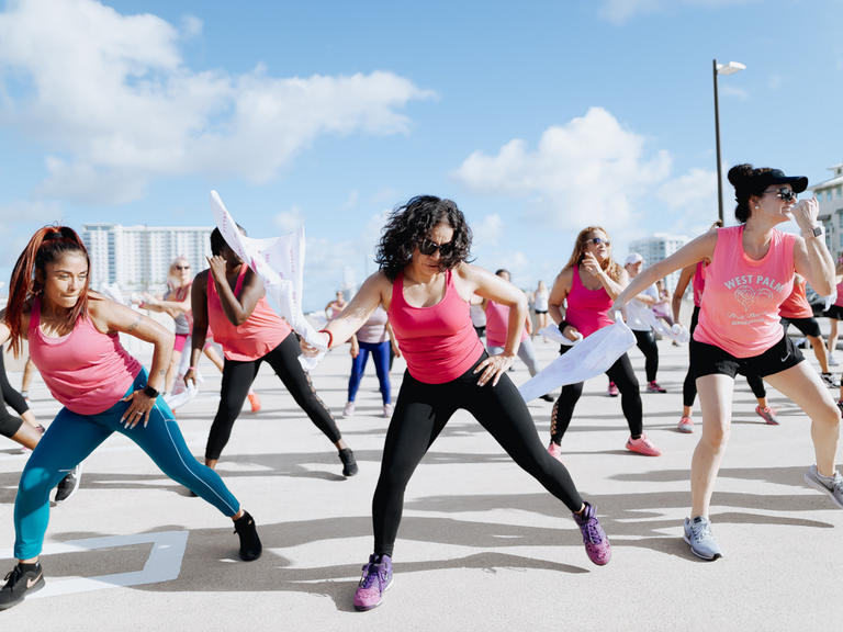 grou pof women in pink tops exercise in sync