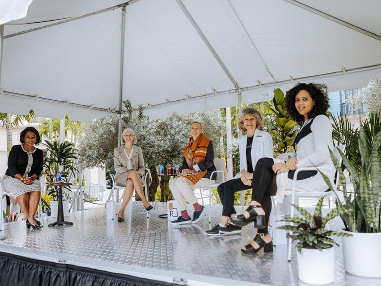 Five women sitting no stage smiling 